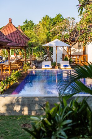 Een buitenzwembad en ligstoelen