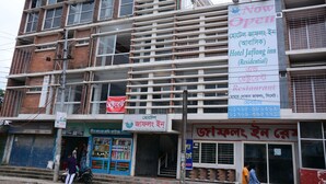 Un edificio a più piani con un cartello che indica che l'Hotel Jaflong Inn è ora aperto.