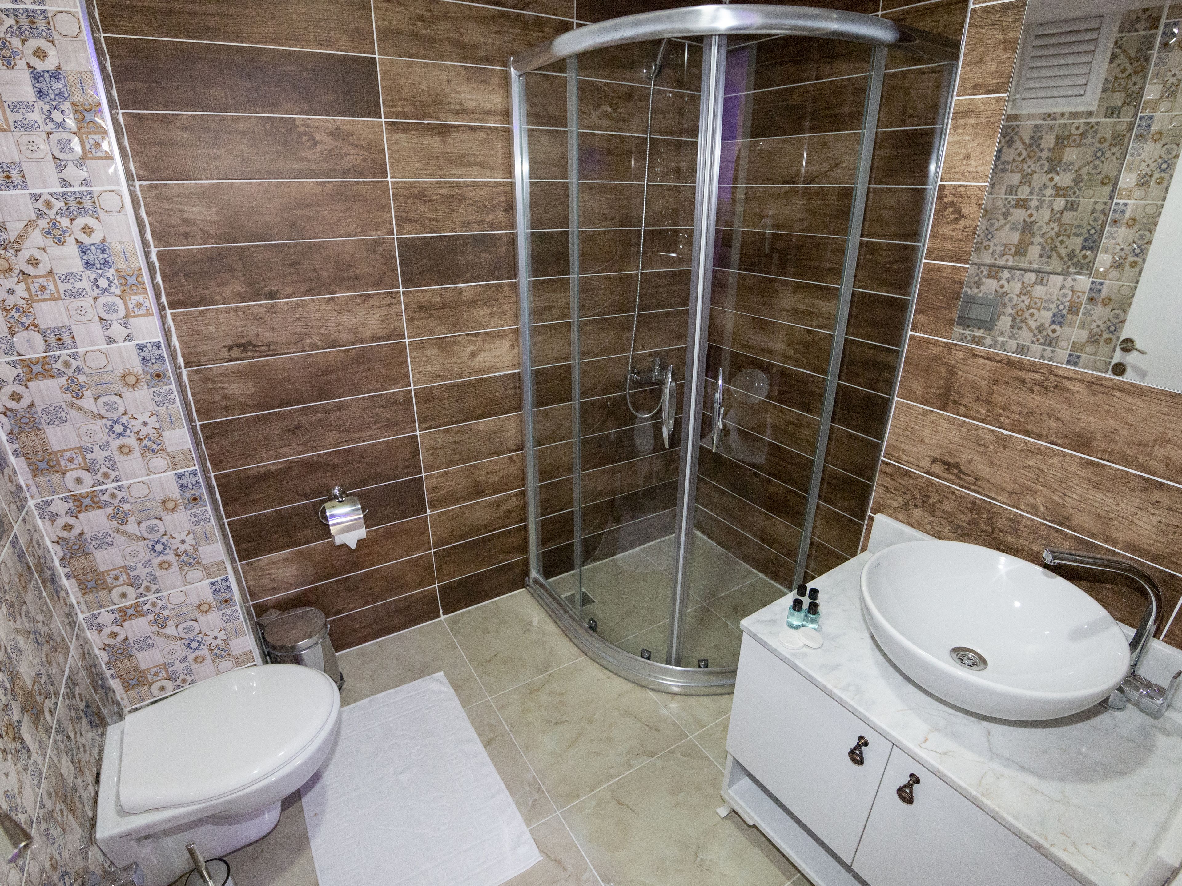 A bathroom with a shower, toilet, and sink.