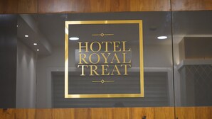 A sign with the text "HOTEL ROYAL TREAT" in a gold frame on a dark background. - Hotel Royal Treat (Surat)