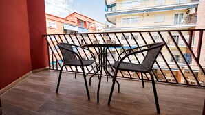 A balcony with two chairs and a table, overlooking a multi-story building with balconies. - GBH Hotel-Apartamentos Caballito de Mar (Benidorm)