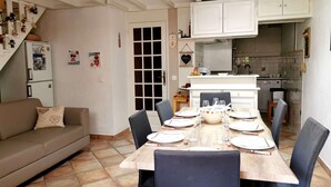 Een knus woongedeelte met een eethoek, kitchenette en een bank.