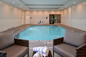 Una piscina techada, sillones reclinables de piscina