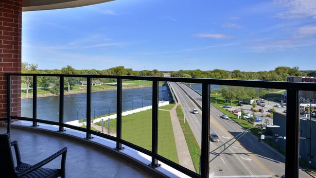 A balcony with a view of a river, a highway, and surrounding greenery. - Hampton Inn Cedar Falls Downtown (Cedar Falls)