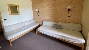 Ein Zimmer mit zwei Holzbänken und einem Spiegel an der linken Wand.