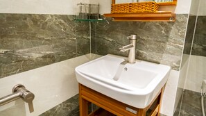 A bathroom with a white sink, a glass shelf, and a marble wall. - AHA Hoang Van Homestay Nha Trang (Bac Nha Trang)