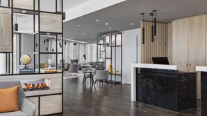 Una sala de estar moderna con chimenea, zona de estar y una isla de cocina con encimera de mármol negro.