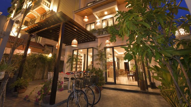 A hotel with a covered outdoor area, potted plants, and bicycles. - Saclo Villa and Hostel (Da Nang)