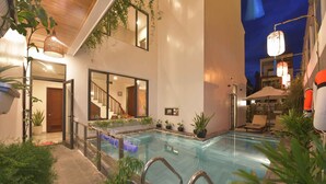 An indoor swimming pool with a view of the interior of the building, including a staircase and a door. - Saclo Villa and Hostel (Da Nang)