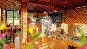 A reception area with a wooden ceiling, reception desk, and a large floral arrangement. - Windy Fields Villa (Nam Hoa Lu)
