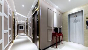 A hotel corridor with a red table, a TV, and a sign reading "HOTEL CHEESE". - Hotel Cheese Ulsan Samsan (Ulsan)