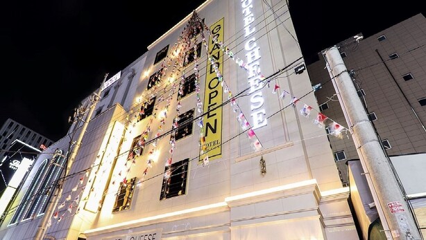 A hotel with multiple floors, illuminated signage, and string lights. - Hotel Cheese Ulsan Samsan (Ulsan)