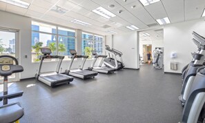 Ein Fitnessraum mit Laufbändern, Fahrrädern und Kraftgeräten.