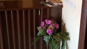 Un mostrador de recepción con detalles de madera, una planta en maceta y un interruptor de luz en la pared.