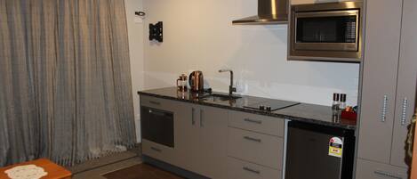 A compact kitchen with a built-in microwave, a dishwasher, and a coffee maker.
