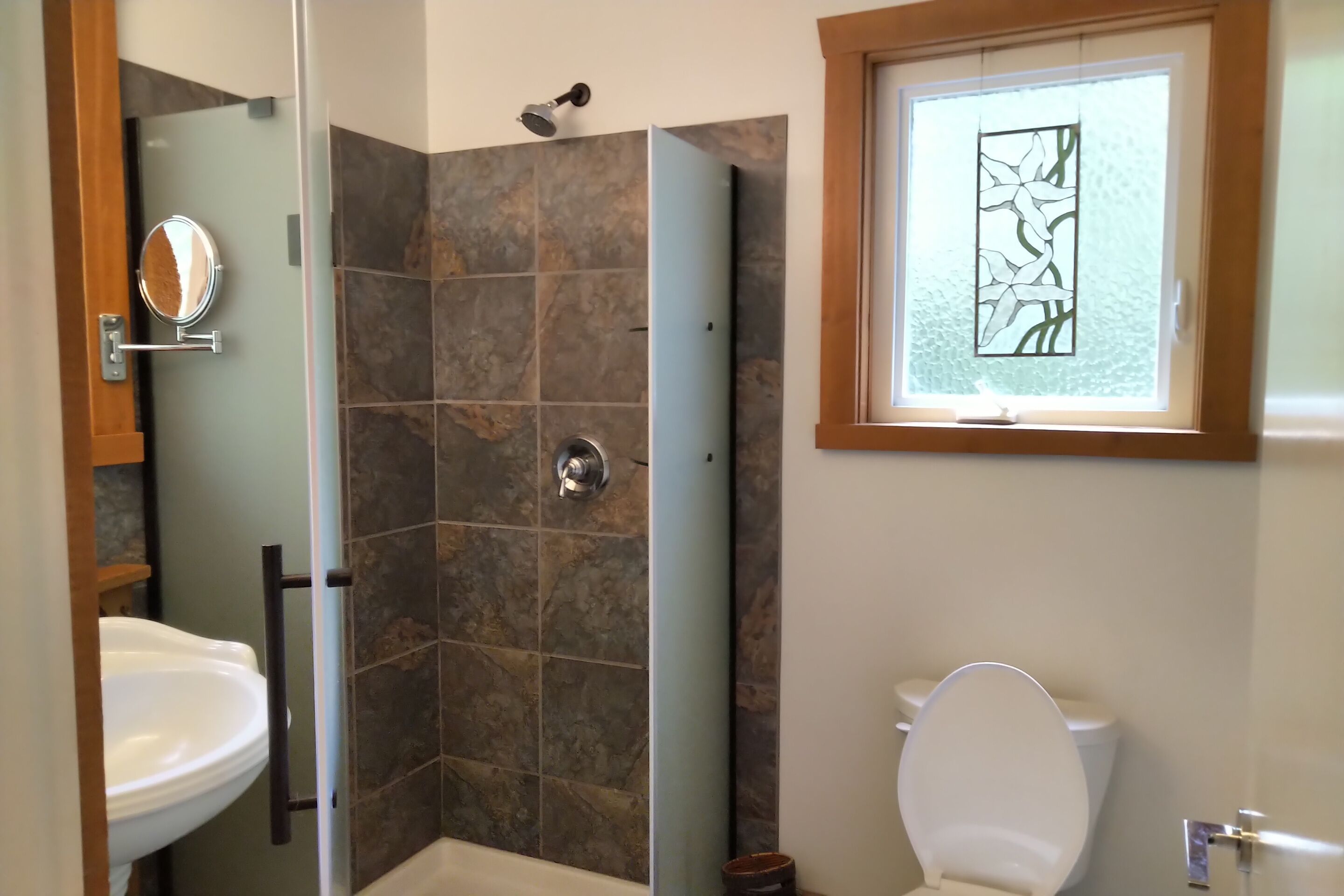Une salle de bain avec douche, toilettes et lavabo.