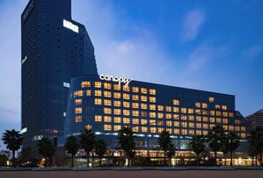 A modern hotel with a prominent 'canopy' sign, featuring a glass facade and multiple floors. - Canopy by Hilton Hangzhou Jinsha Lake (Hangzhou)
