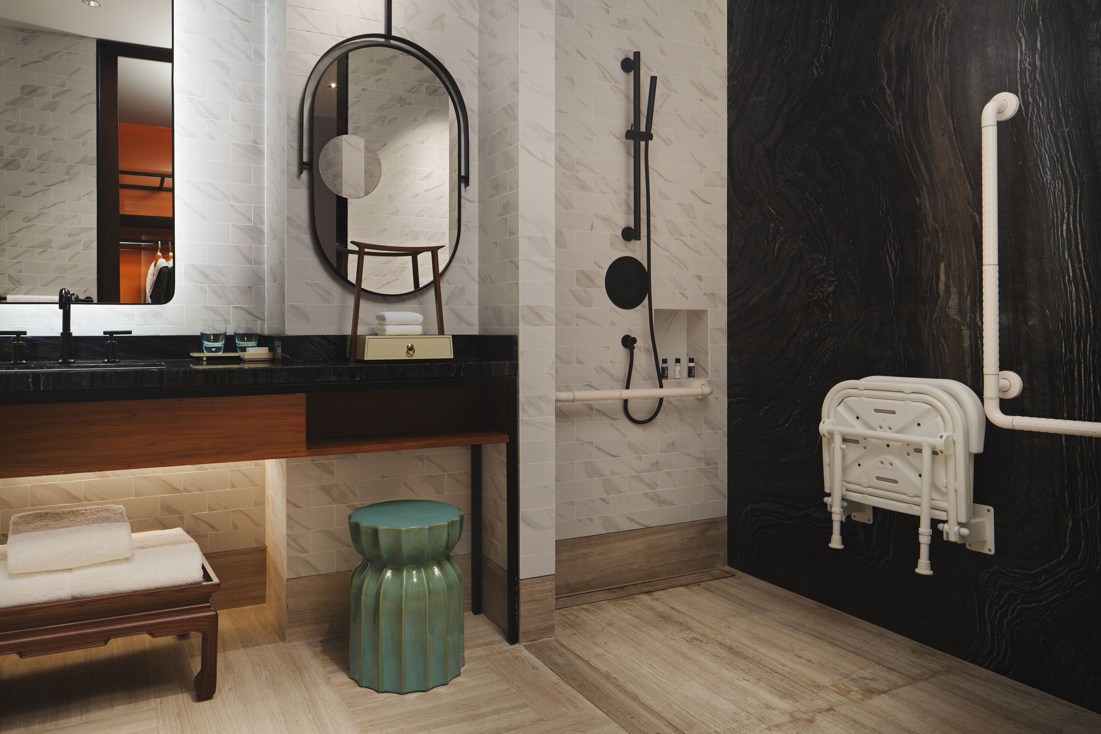 Un baño moderno con tocador, espejo, perchero y zona de ducha.