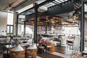 A modern restaurant with high ceilings, exposed beams, and a bar area. - Yello! Hotel (Cebu City)