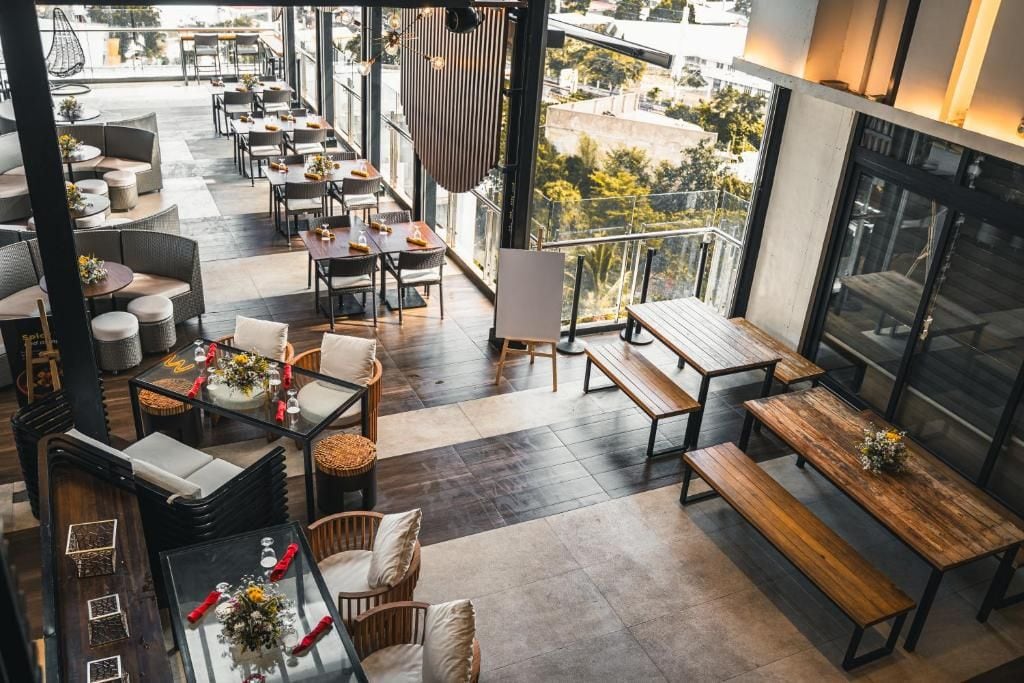 Una terrazza sul tetto con posti a sedere all'aperto, tra cui tavoli e panchine, e vista sulla città.
