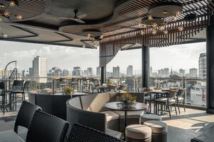 A rooftop bar with outdoor seating, city views, and modern design elements.