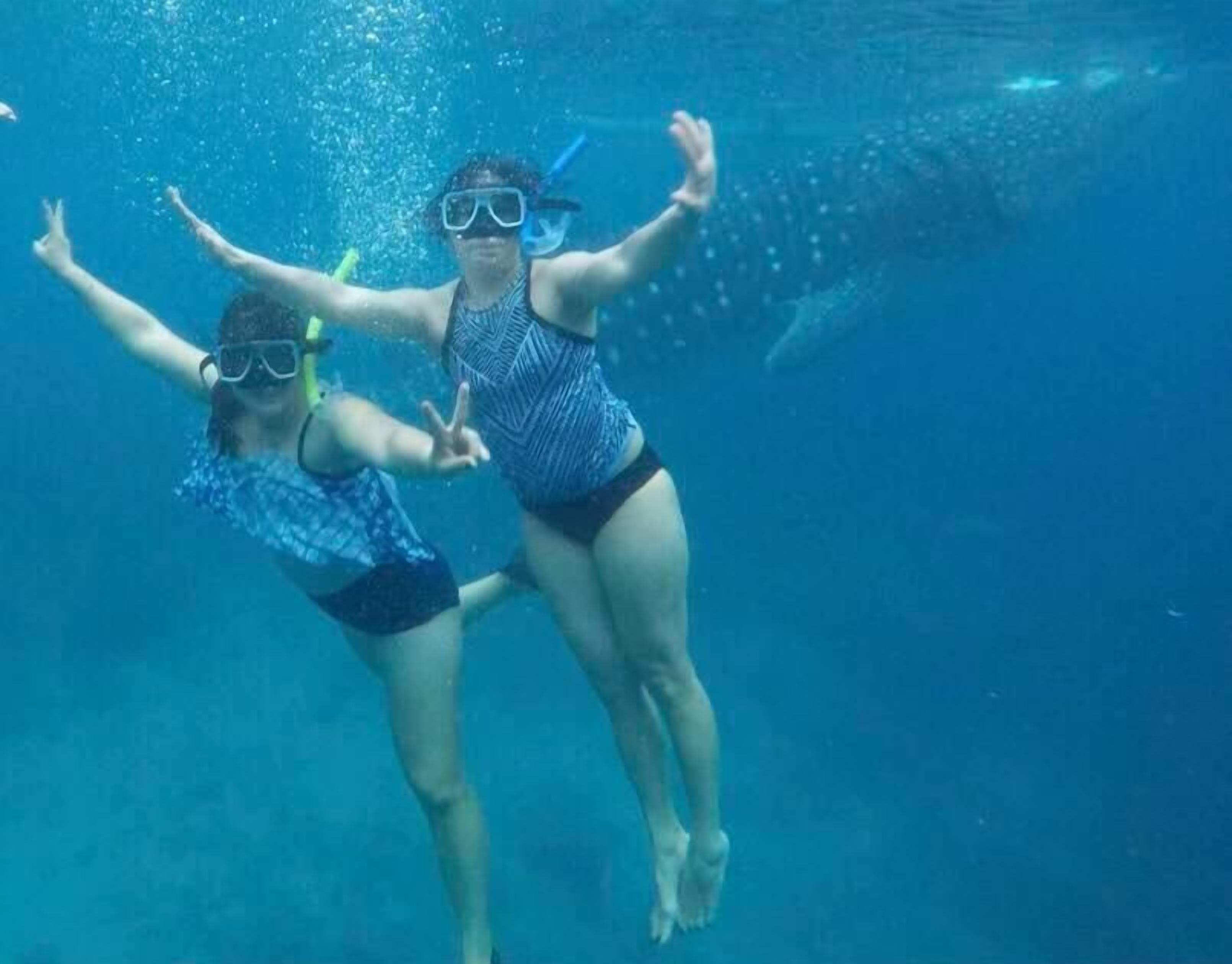 Dos personas haciendo snorkel bajo el agua.