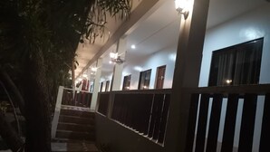 Un pasillo con una escalera, una barandilla y una planta.