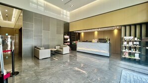 A modern lobby with a reception desk, seating area, and a water dispenser. - Hotel A . Tainan (Tainan)