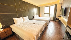 A hotel room with two beds, a TV, a desk, and a window with curtains. - Hotel A . Tainan (Tainan)