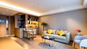 Un salon moderne avec un canapé, une table basse et un petit coin repas.