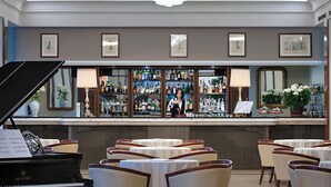 Un espace bar avec un piano, des tables et des chaises.