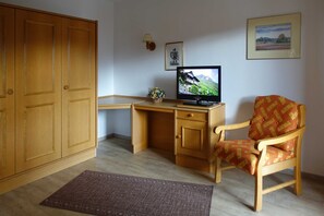 A room with a wooden desk, a television, a chair, and a wardrobe. - Neureuth - House Schußmann (Tegernsee)