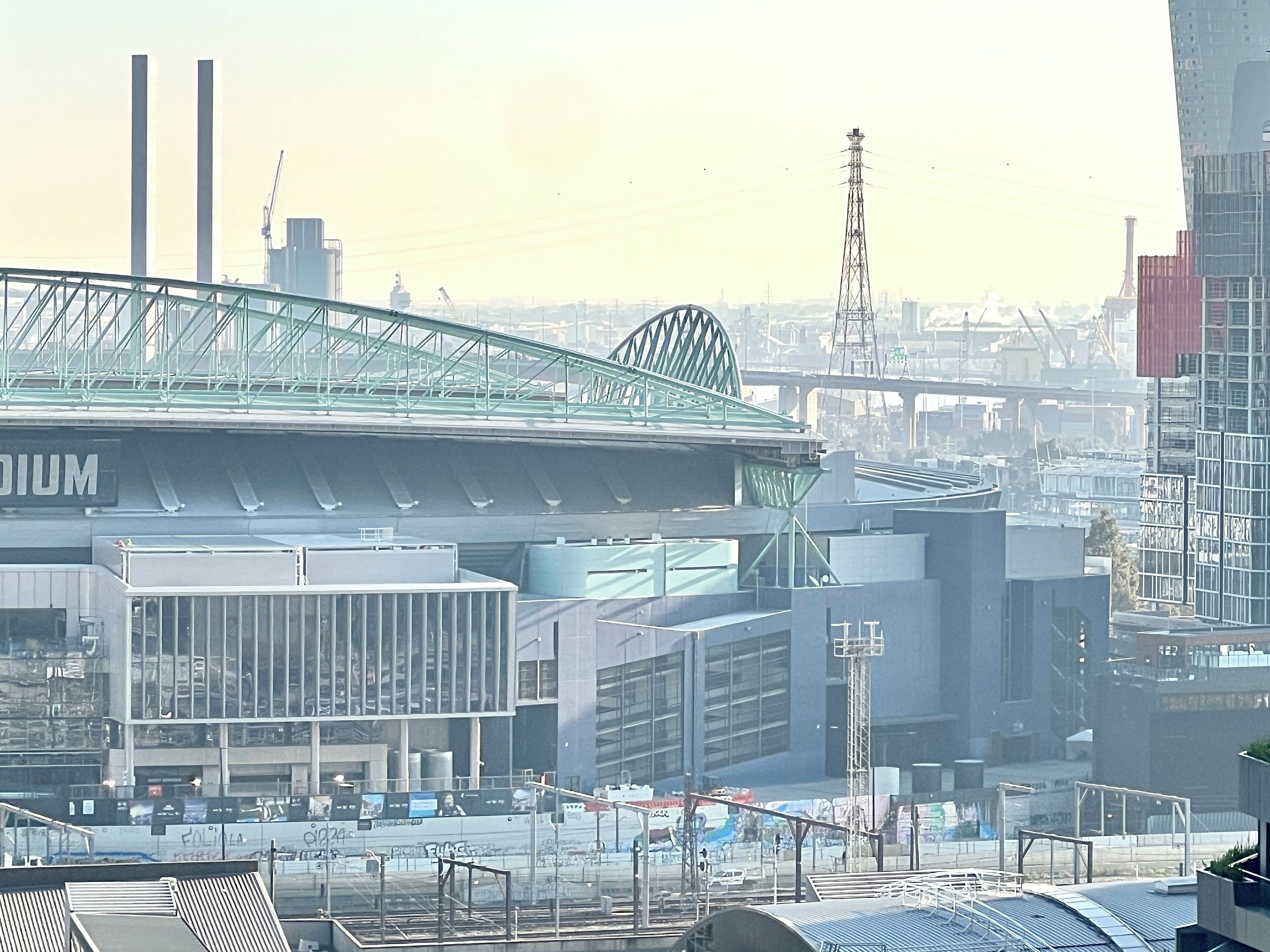 Un estadio con una amplia estructura de techo, rodeado de edificios urbanos y obras en construcción.
