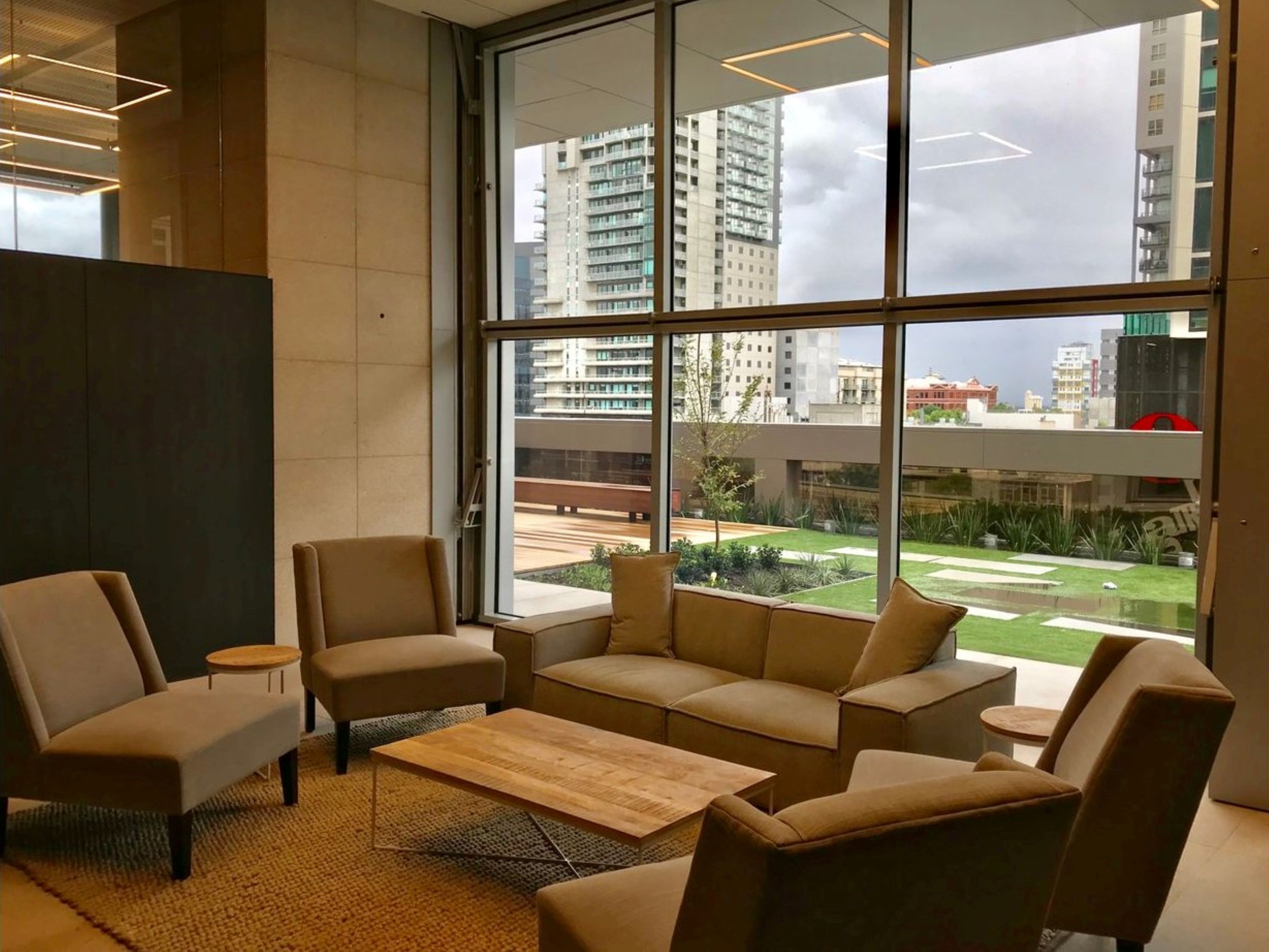 Un interno moderno con un'ampia finestra, posti a sedere confortevoli e vista sulla città.