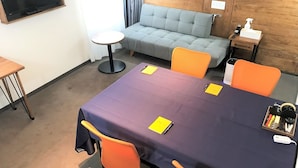 A conference room with a table, chairs, and a sofa.