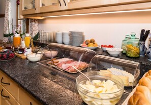 Ein reichhaltiges Buffet mit verschiedenen Speisen, darunter Obst, Käse und Fleisch.