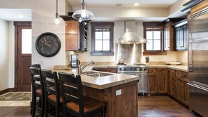 Una cocina moderna con una isla central, electrodomésticos de acero inoxidable y muebles de madera.
