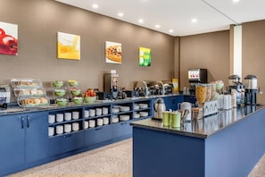 A self-service breakfast bar with various food items, bowls, and utensils. - Quality Inn & Suites (Mont Joli)