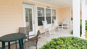 Eine überdachte Veranda mit Tisch und Stühlen, eine Tür und ein Schild mit der Aufschrift 'NeeNee and Papas Florida House'.