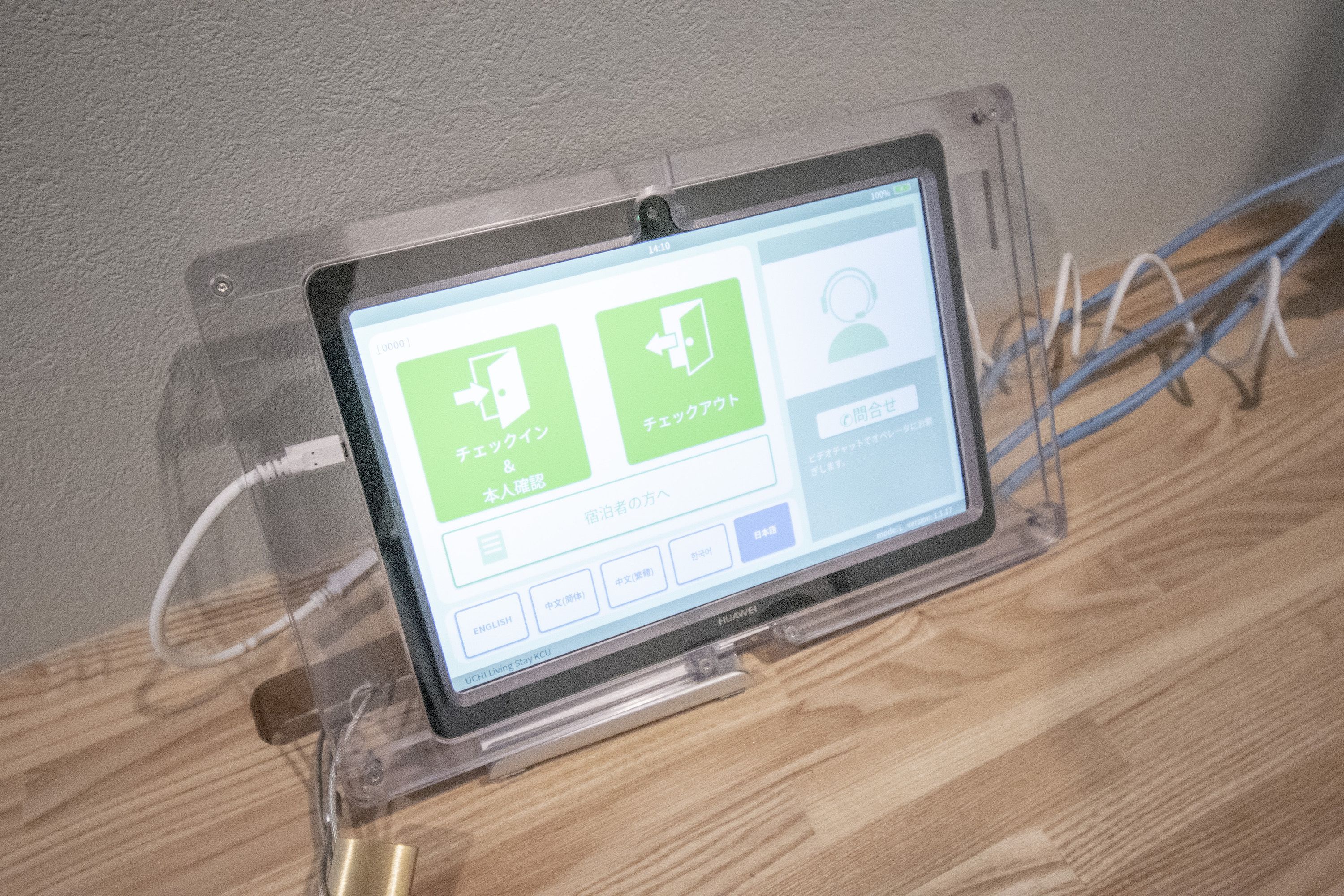 A tablet on a stand displaying a user interface with Japanese text.