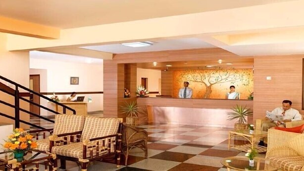 Um saguão de hotel com balcão de recepção, balcões de check-in e áreas de estar.