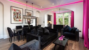 A modern living room with black furniture, a dining area, and a kitchen visible through an archway. - Kotel Windermere (Windermere)