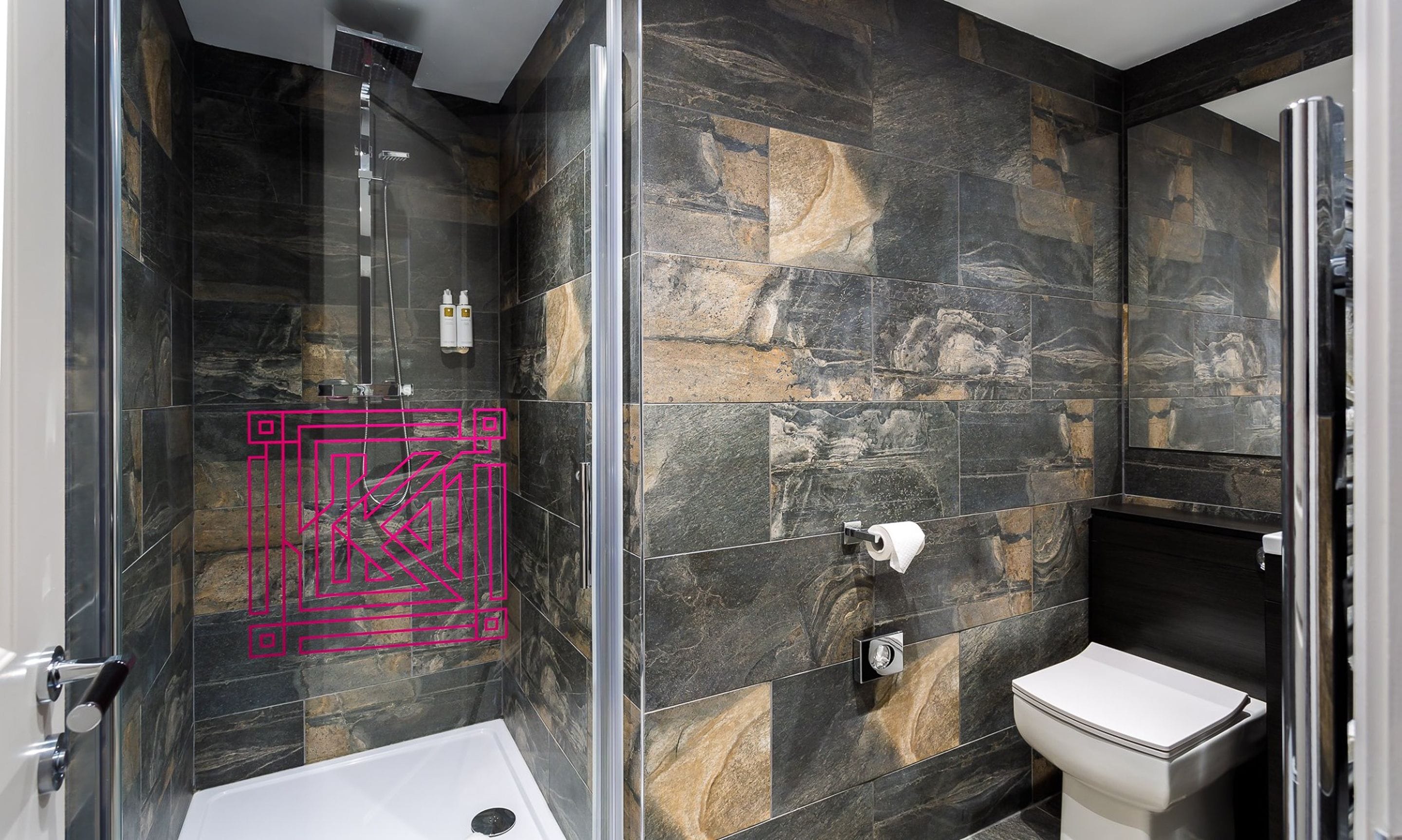 A modern bathroom with a glass shower enclosure, a toilet, and a sink.