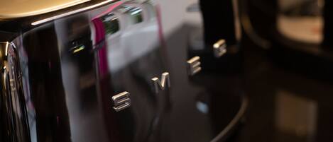 A close-up of a metallic, reflective surface with the letters "M" and "E" visible.