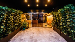 A hotel entrance with a tiled floor, glass doors, and potted plants on either side. - HOTEL Tokyo Trip Ueno Nishi Nippori (Tokyo)