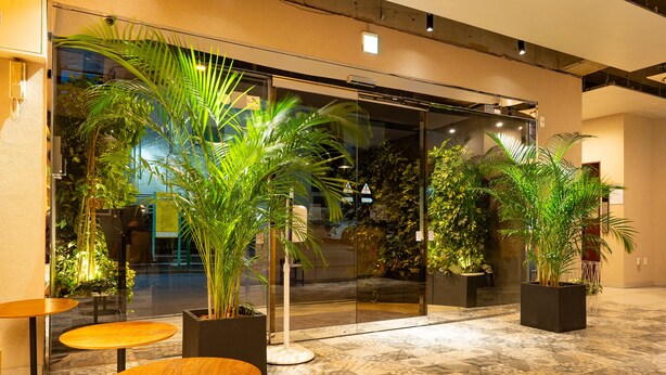 A lobby with glass doors, potted plants, and tiled flooring. - HOTEL Tokyo Trip Ueno Nishi Nippori (Tokyo)