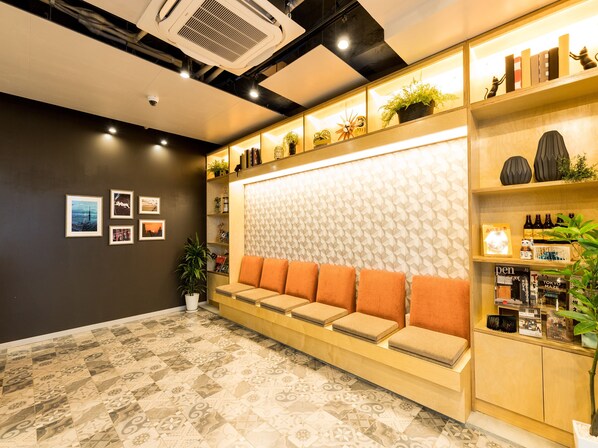 Um interior moderno com área de estar, piso estampado e diversos objetos decorativos nas prateleiras.