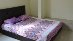 Un dormitorio con cama, ventilador de techo y aire acondicionado.