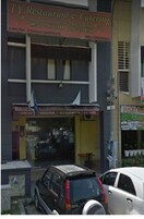 A TY Restaurant & Catering building with a visible storefront and parked cars in front.