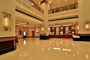A spacious lobby with a high ceiling, a central reception desk, and a staircase connecting multiple floors. - Hangzhou Wenhua Jinglan Grand Hotel (Hangzhou)